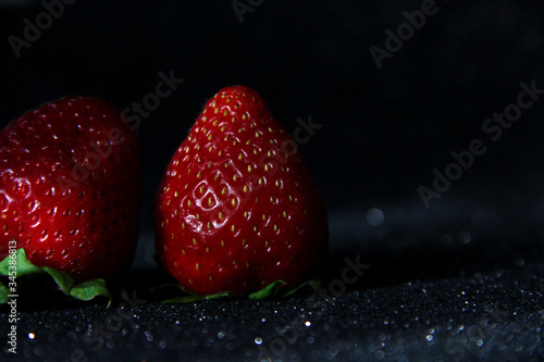 Strawberry on a black background. Brilliant background with berries.