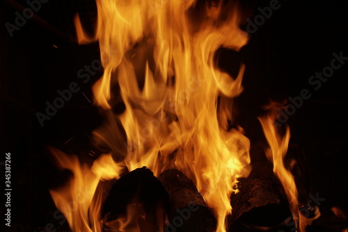 firewood burning in fireplace on dark background