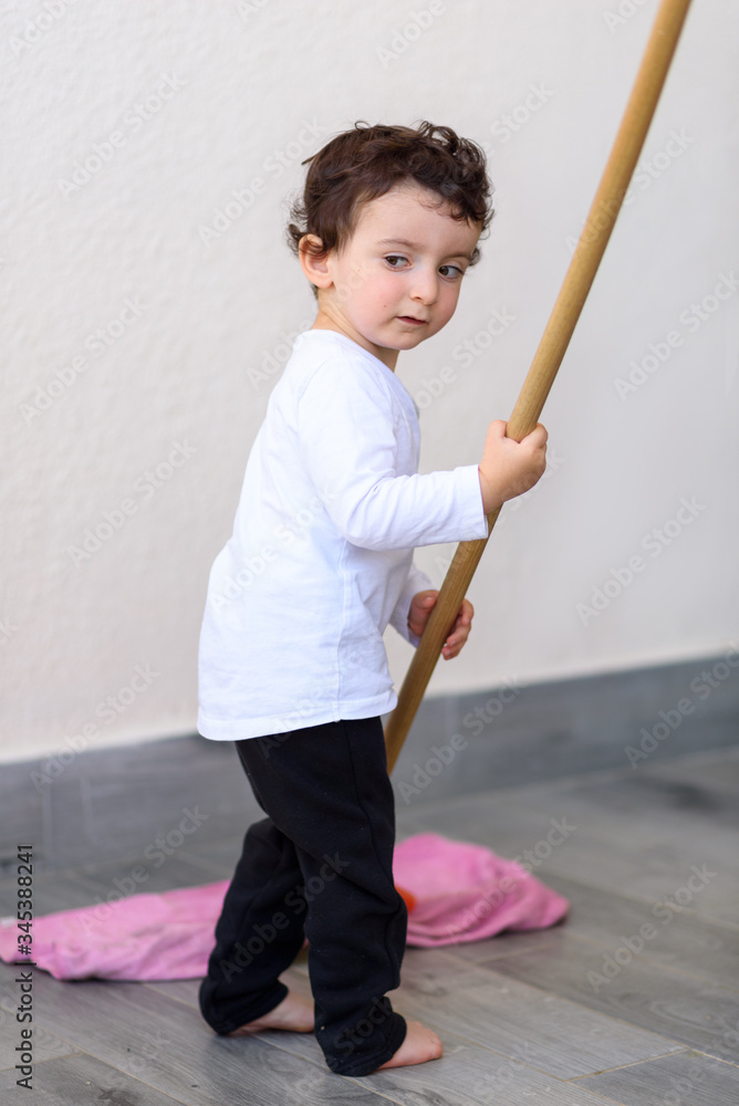 Portrait of little funny boy cleaning tile floor with mop and rag. Portrait of little funny boy cleaning tile floor with mop and rag.