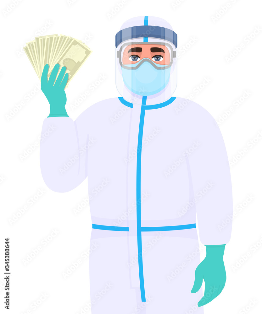 Man in safety protection suit, medical mask, glasses and face shield showing cash, money. Doctor or physician holding currency notes. Surgeon or scientist wearing personal protective equipment (PPE).