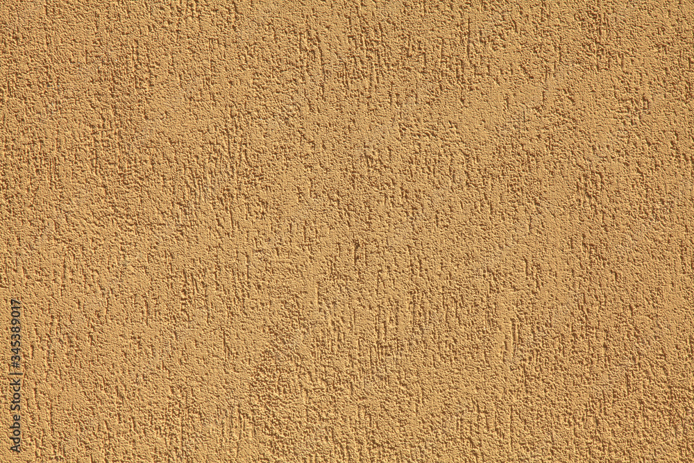 Obraz premium Yellow wall, texture, background. Plastered building wall, painted with water-based paint. Decorated surface with embossed pattern and strokes in abstract style. Elements of the exterior and interior