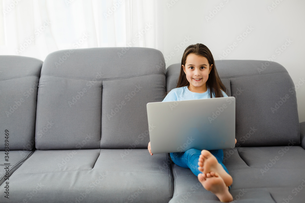Cute little girl using laptop at home. Education, online study, home studying, distance learning, schoolgirl children lifestyle concept Cute little girl using laptop at home. Education, online study, home studying, distance learning, schoolgirl children lifestyle concept