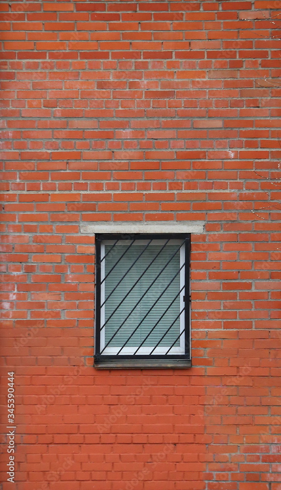 Barred window in the red brick wall