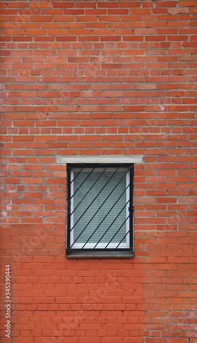 Barred window in the red brick wall