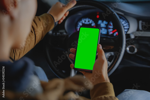 Driver in car holding phone. © Aleksandr Ride