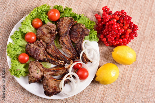 barbecue on a plate with herbs and vegetables. Russian restaurant. The concept of the menu.