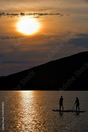 Sup boarding couple on sunset