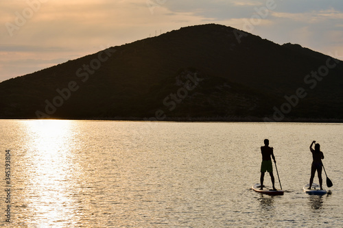 Sup boarding couple on sunset