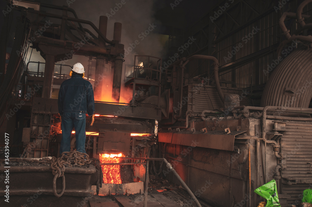 man melting steel in hot factory man melting steel in hot factory