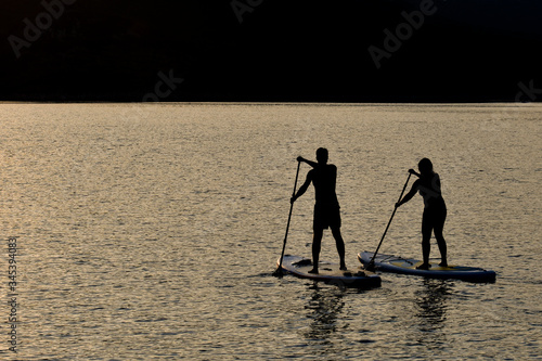 Sup boarding couple on sunset