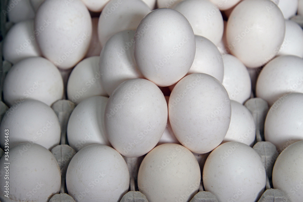 a lot of fresh white chicken eggs on the counter in the store a lot of fresh white chicken eggs on the counter in the store