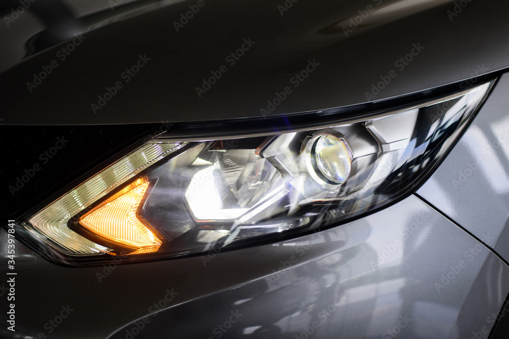 Headlights of grey car. Garage theme