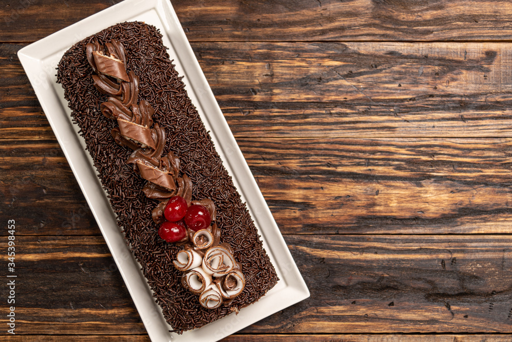 A delicious Swiss roll on woodden background. Sponge roll cake. Brazilian dessert. Rocambole cake A delicious Swiss roll on woodden background. Sponge roll cake. Brazilian dessert. Rocambole cake