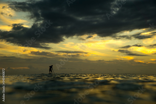 Paddle surfing at sunset
