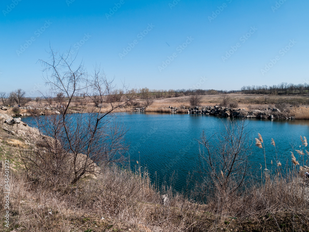 lake with blue water. dry grass