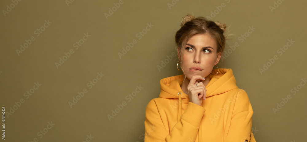 Image of a dreaming pleased young pretty woman posing isolated over green background.