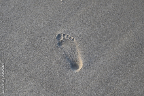 Śład małej stopy na plażowym piasku