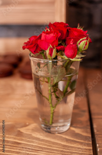 Red rose flowers in a glass with water