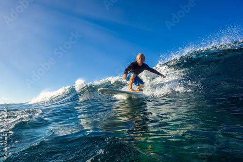 muscular surfer with long white hair riding on big waves on the Indian Ocean island of Mauritius