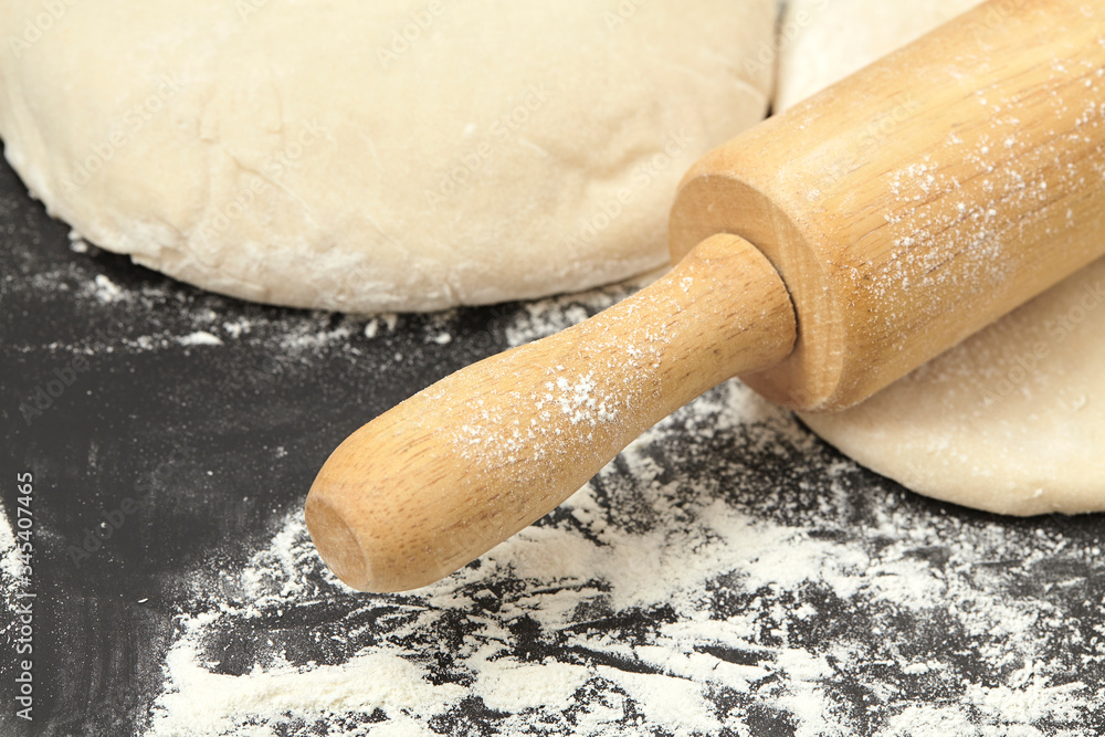 Dough and wood rolling pin on clean black background Close up Dough and wood rolling pin on clean black background Close up