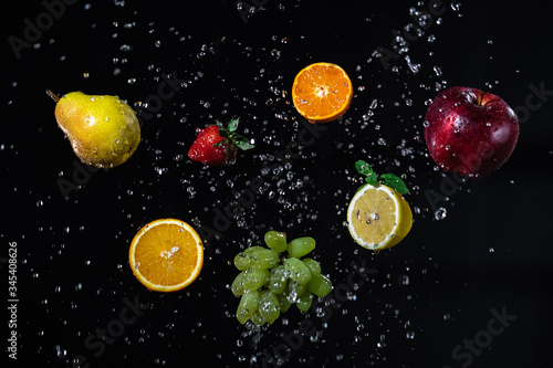 flying fruits with drops of water on a black background