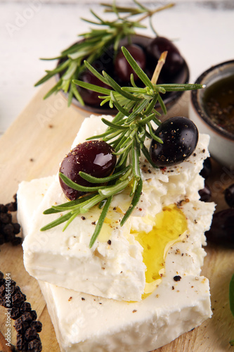 Greek cheese feta with rosemary and olives. Healthy ingredient for cooking salad. Chopped Goat feta cheese with gourmet herbs