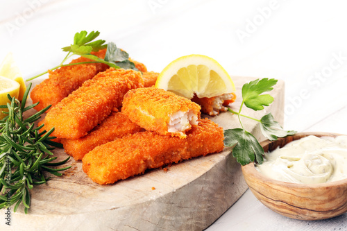 fresh fish fingers with remoulade sauce. breaded fish fingers with lemon and remoulade