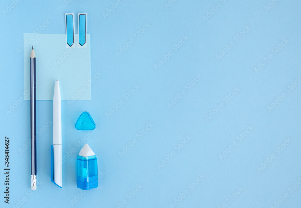 Flat lay with set of stationery: pen, pencil, eraser, paper on blue background. Top view, copy space, monochrome. Back to school, education, office concept.