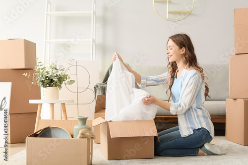 Young woman unpacking movin...