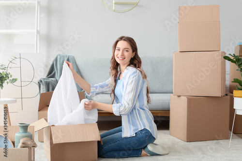Young woman unpacking movin...