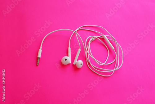 Headphones for a smartphone on a bright background, modern technology. © Elena Shap