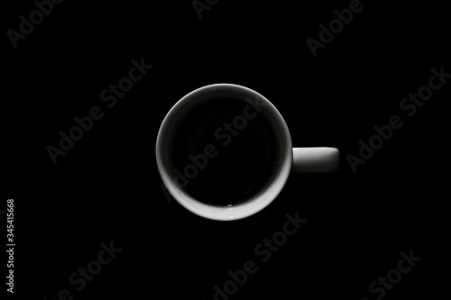 Cup with coffee on black background. Morning coffee top view.