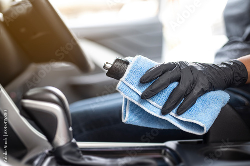 This image is a picture of wiping the car by a blue microfiber cloth with hand wearing gloves.