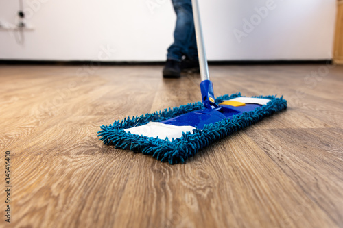 mop closeup in the hands of a man. general cleaning in the apartment and office.