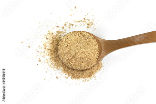 Ground biscuits in a wooden spoon on white background.