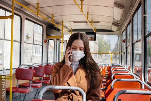 A young girl in a mask uses public transport alone, during a pandemic. Protection and prevention covid 19