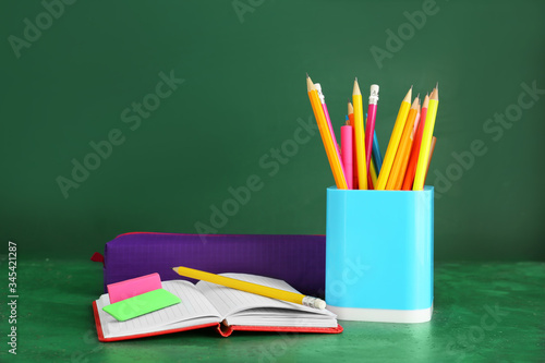 Holder with stationery on color background