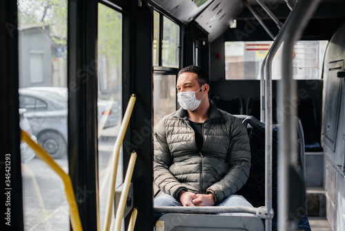 A young masked man uses public transport alone during a pandemic. Protection and prevention covid 19