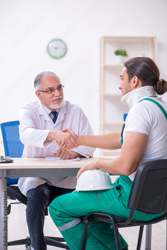 Obraz premium Young male contractor visiting old doctor