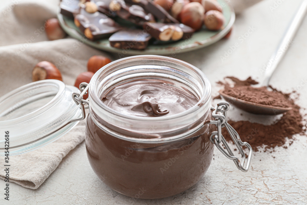 Jar with tasty chocolate paste on light background Jar with tasty chocolate paste on light background