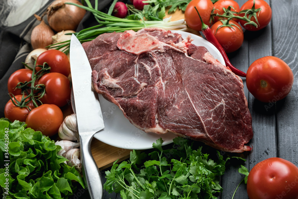 a piece of fresh choice beef lies on a wooden chopping Board. Fresh meat and vegetables Juicy steak with greens. Proper, balanced nutrition. a piece of fresh choice beef lies on a wooden chopping Board. Fresh meat and vegetables Juicy steak with greens. Proper, balanced nutrition.