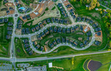 High resolution aerial view of a new residential real estate development with single family houses, home sites, community pool, curving streets in the East Coast USA