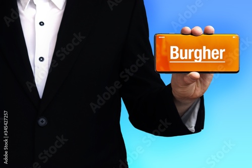 Burgher. Lawyer in a suit holds a smartphone at the camera. The term Burgher is on the phone. Concept for law, justice, judgement