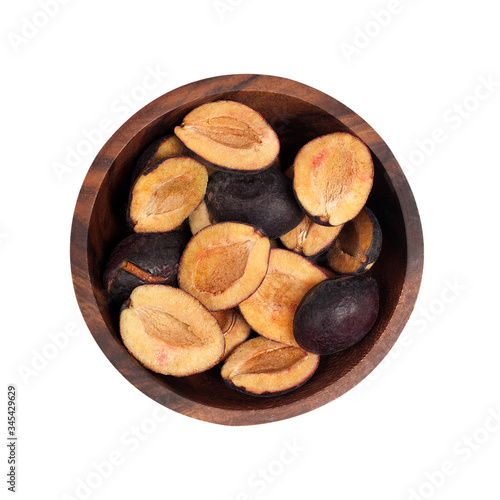 dried plums in a brown wooden dish. Dried fruits.