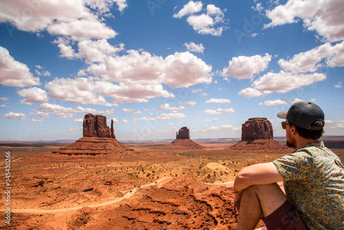 Man in summer time sitting on view point for Monument Valley in Arizona Utah United States of America. Travelling, road trip, adventure time. 