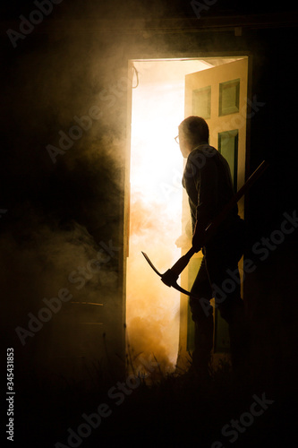 man entering smoking house on fire
