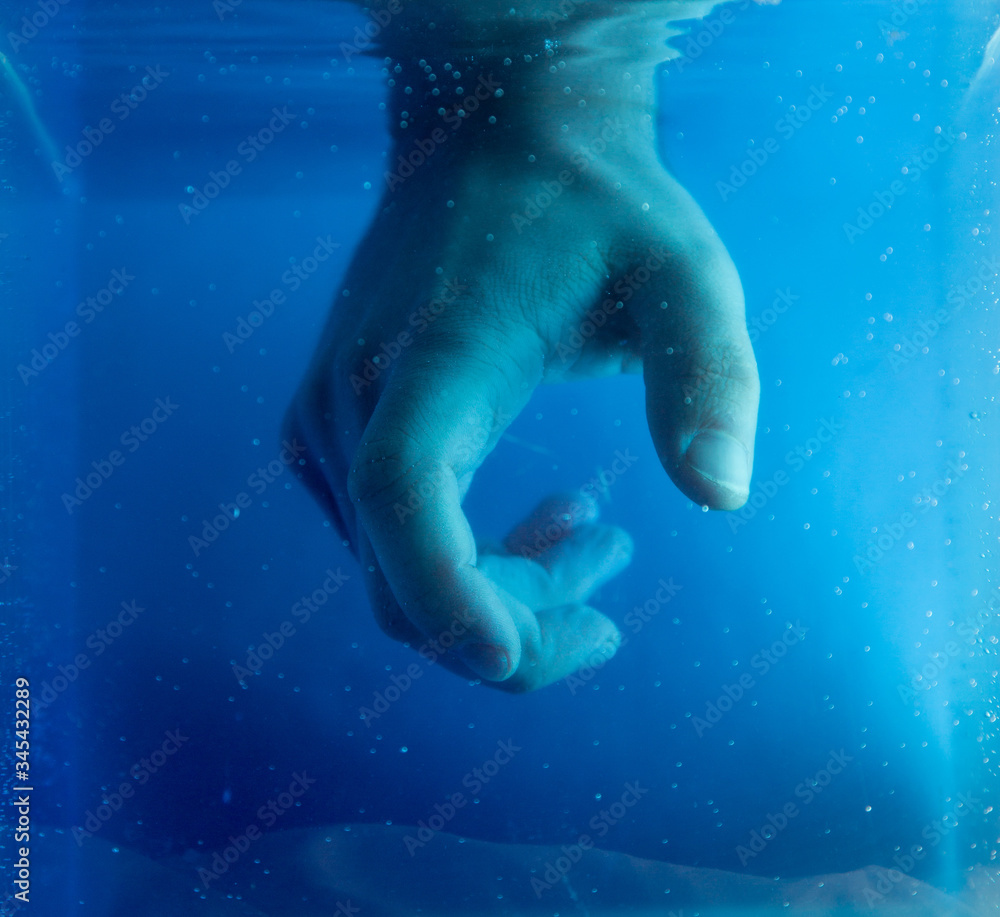 Fototapeta premium Artistic view of hand under colored water