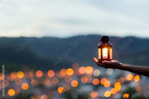Moroccan lantern lit with city lights in the background photo