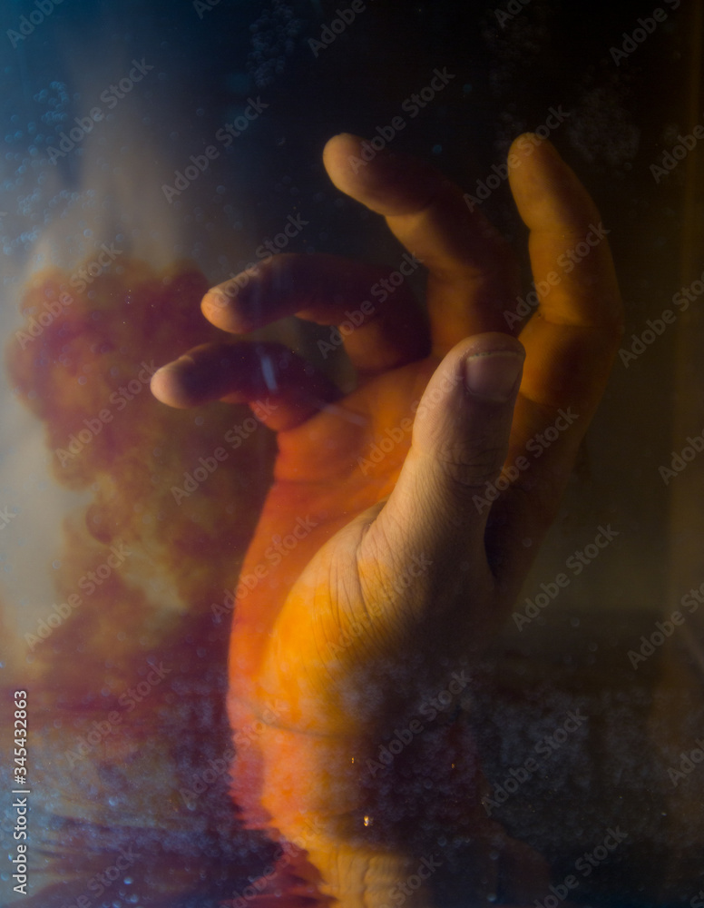 Artistic view of hand under colored water