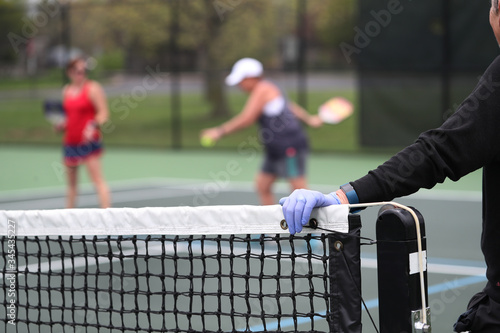 Rubber gloves are used by a pickleball player that is waiting to play.